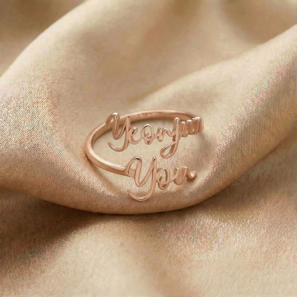 Personalized name ring, one-size in rose gold finish on beige silk fabric