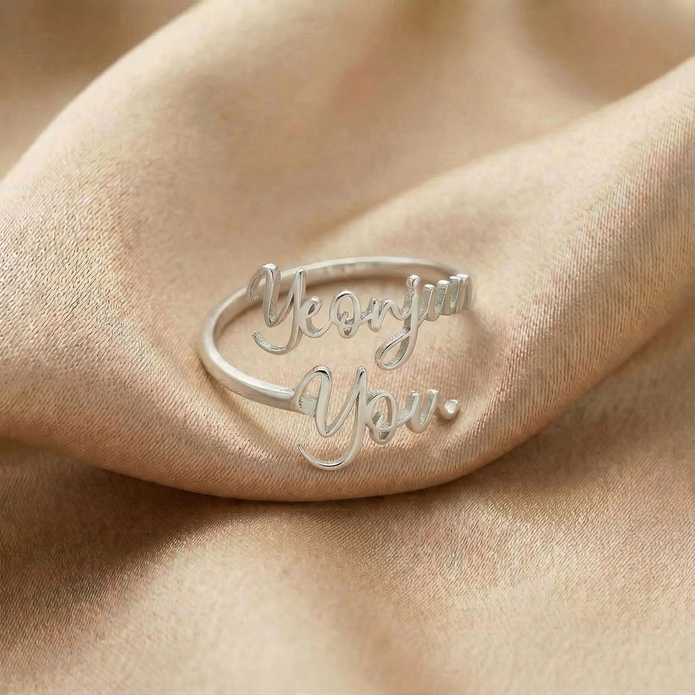 Personalized name ring, one-size in silver finish on beige silk fabric