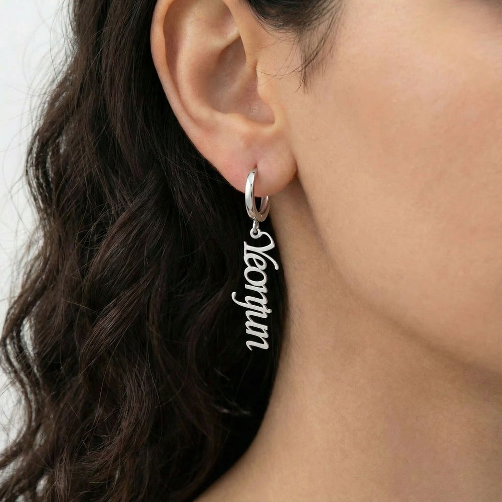 Personalized name drop earrings in silver finish worn on ear, side profile view