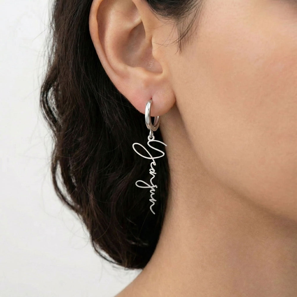Personalized name drop earrings in silver finish worn on ear, side profile view
