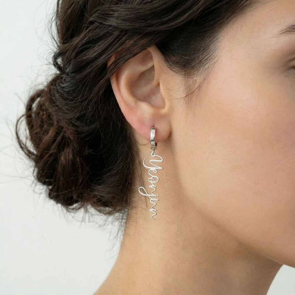 Personalized name drop earrings in silver finish worn on ear, side profile view