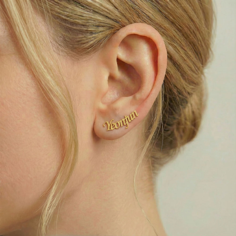 Personalized name ear climber earrings in gold finish worn on ear, side profile view