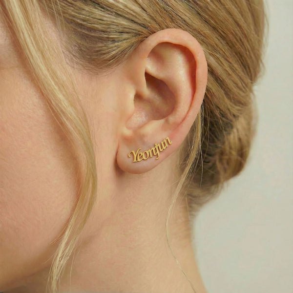 Personalized name ear climber earrings in gold finish worn on ear, side profile view