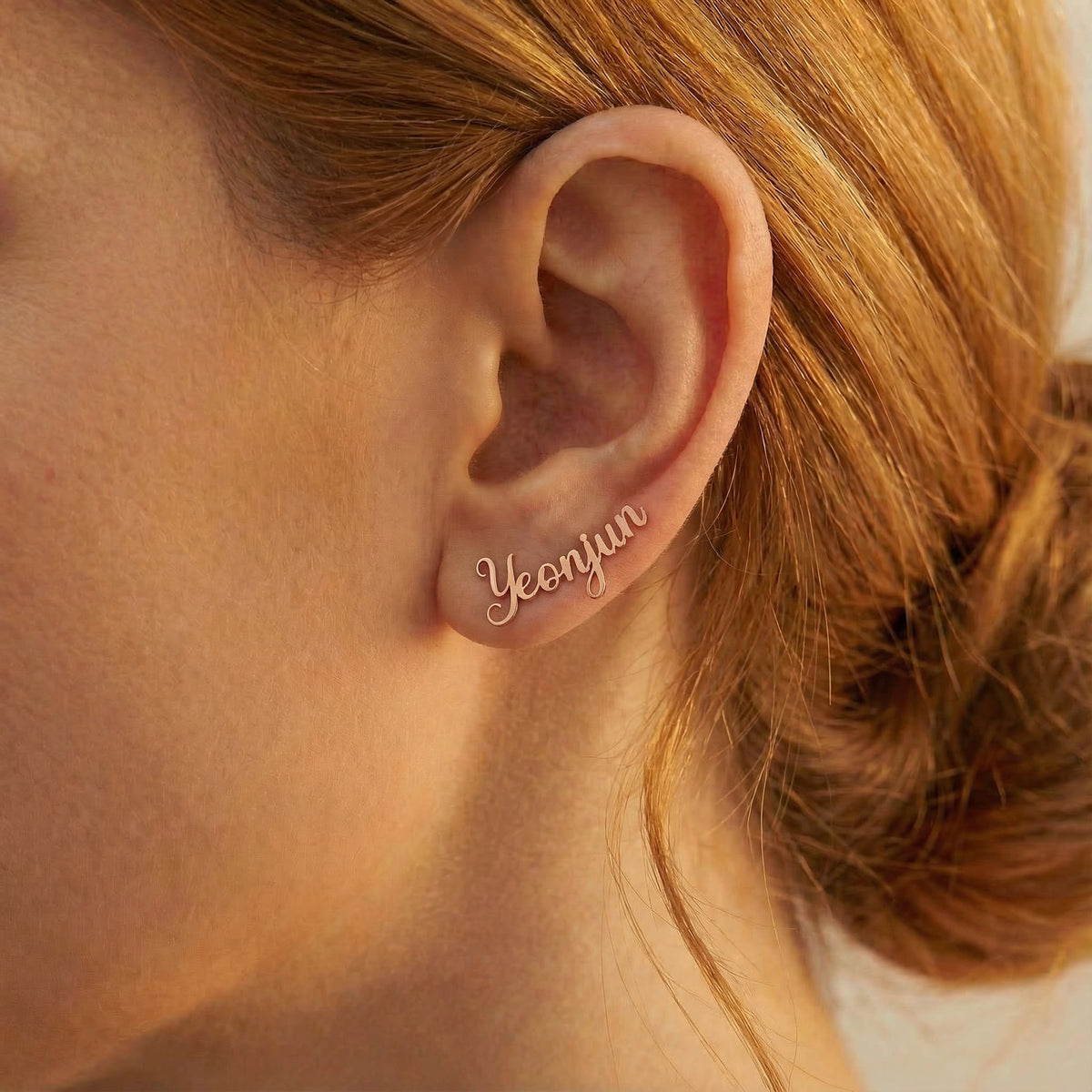 Personalized name ear climber earrings in rose gold finish worn on ear, side profile view