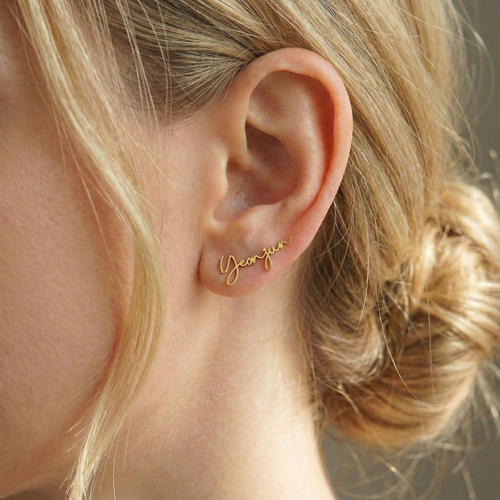 Personalized name ear climber earrings in gold finish worn on ear, side profile view