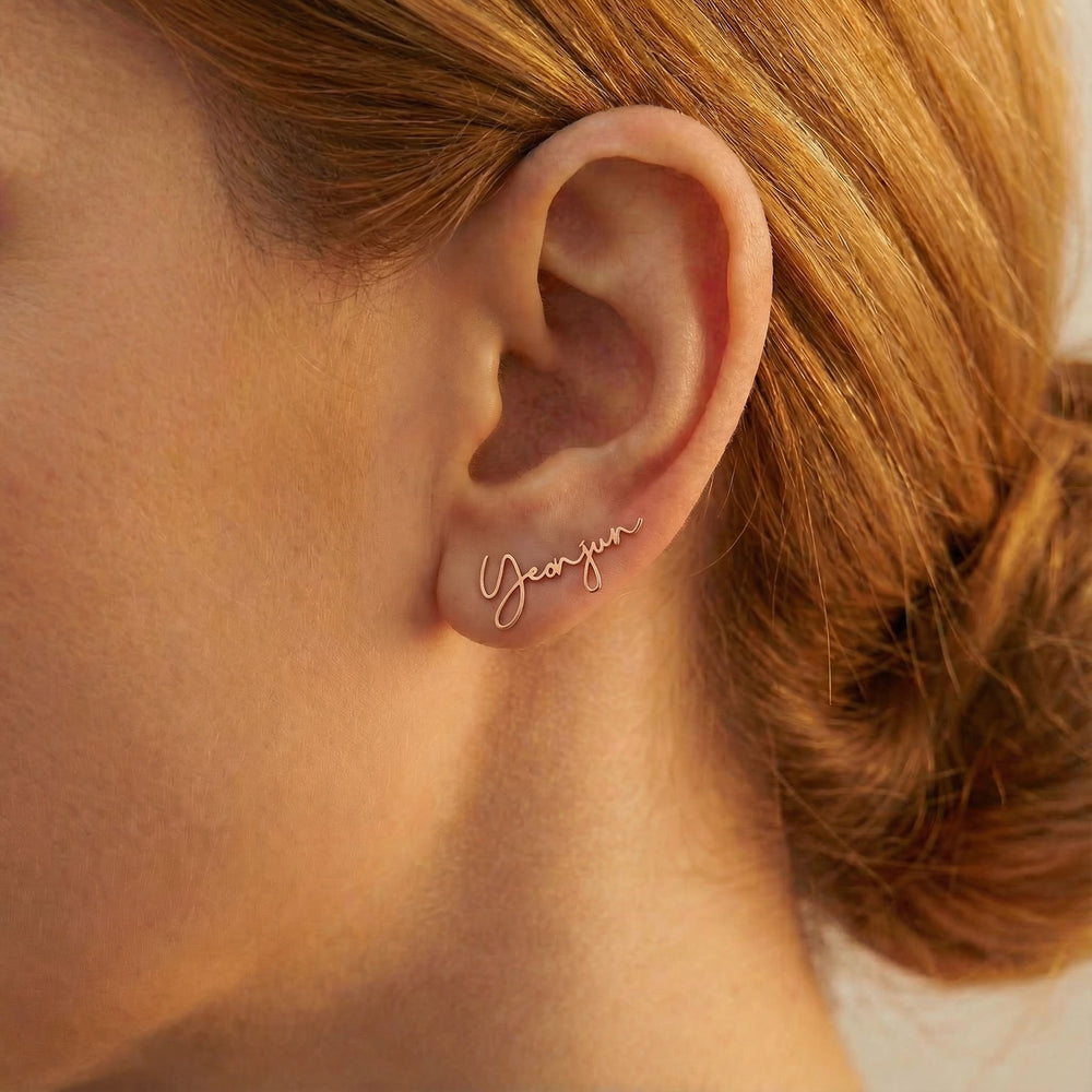 Personalized name ear climber earrings in rose gold finish worn on ear, side profile view
