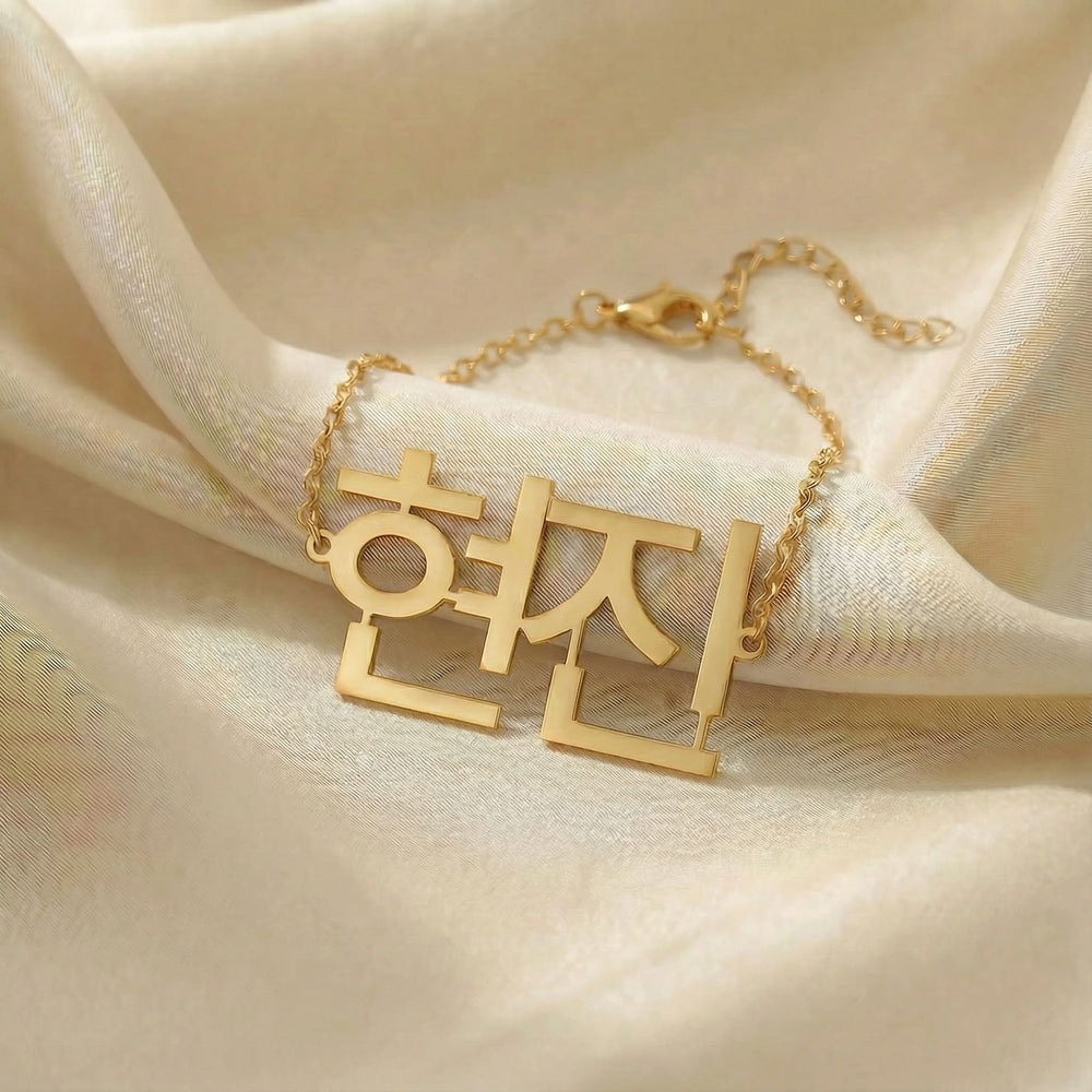 Personalized name bracelet in Korean in gold finish on beige silk fabric