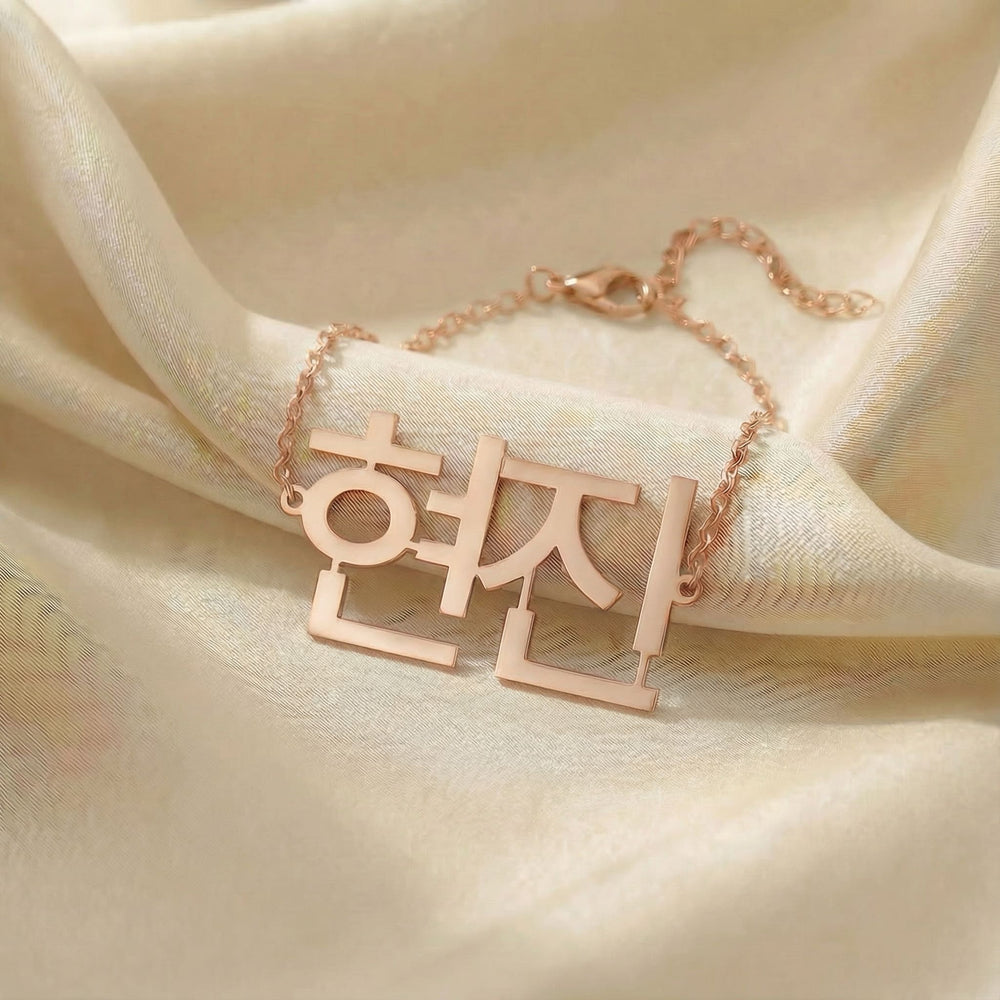 Personalized name bracelet in Korean in rose gold finish on beige silk fabric