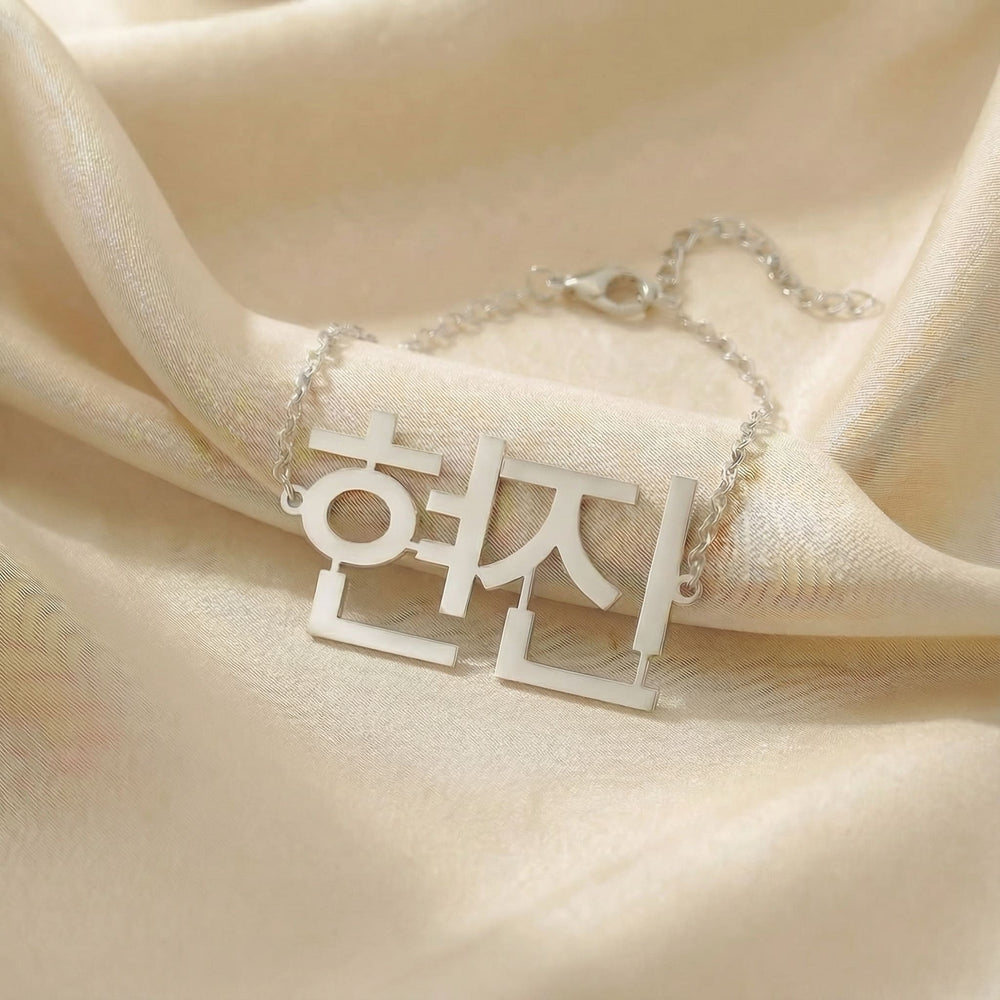 Personalized name bracelet in Korean in silver finish on beige silk fabric