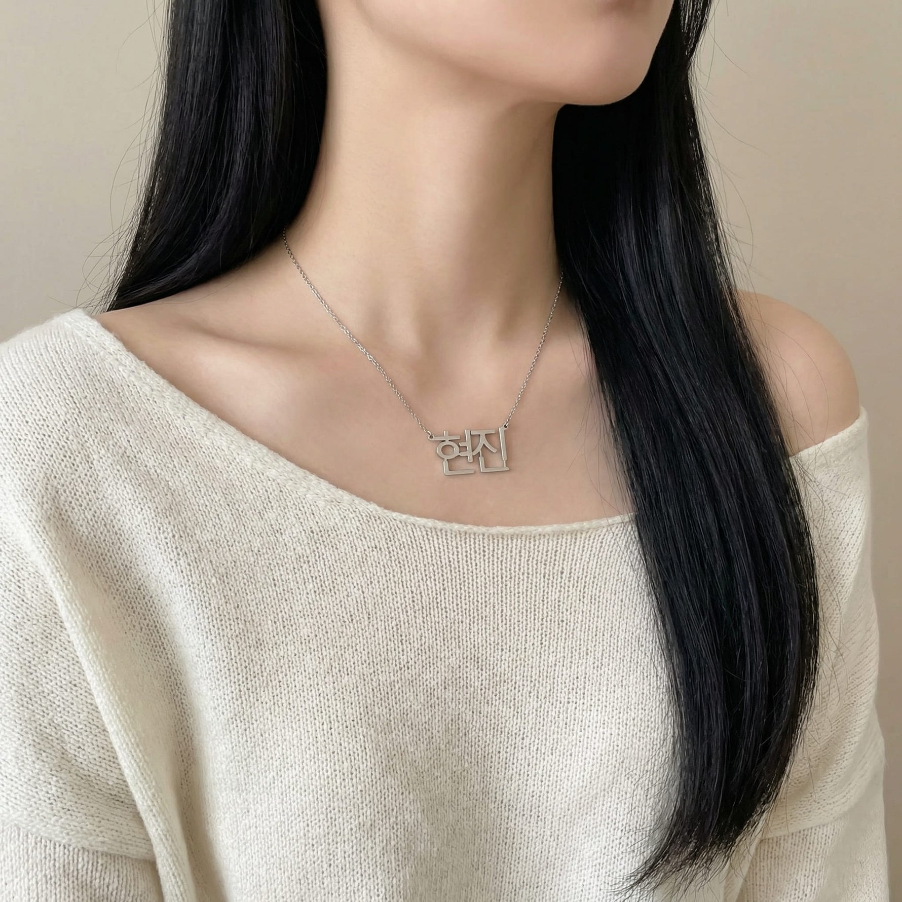 Silver Korean Hangul K-pop idol name necklace reading 현진 worn on woman’s neck