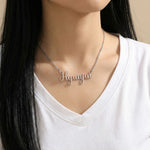 Silver Latin script K-pop idol name necklace reading Hyunjin worn on woman’s neck
