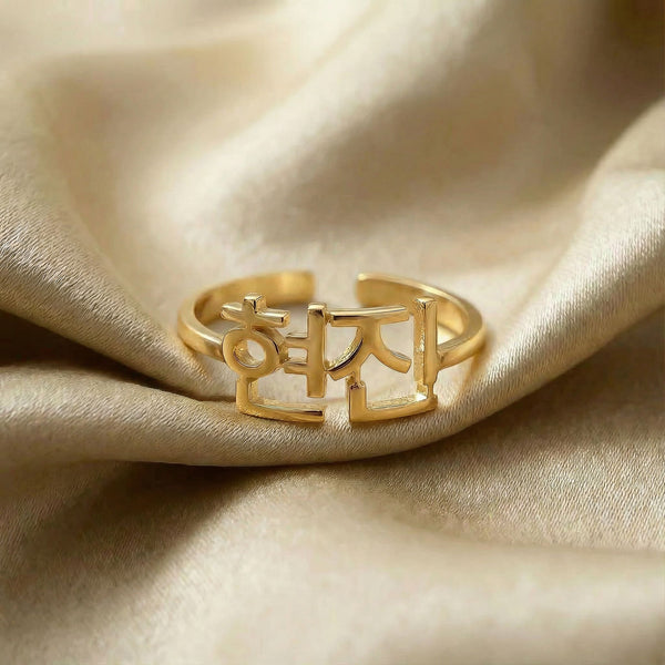 Personalized name ring in Korean, one-size in gold finish on beige silk fabric