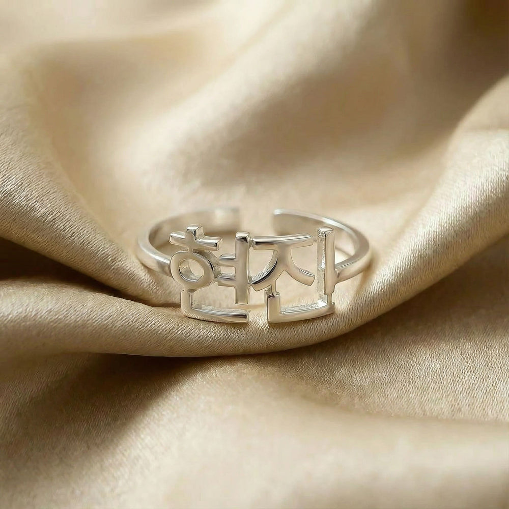 Personalized name ring in Korean, one-size in silver finish on beige silk fabric