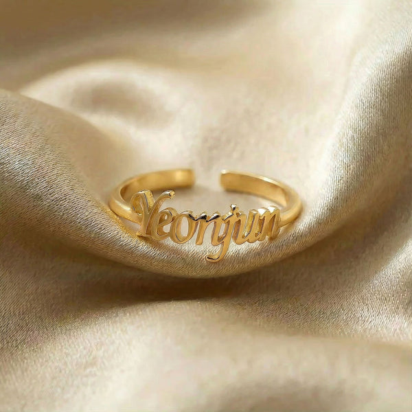 Personalized name ring, one-size in gold finish on beige silk fabric