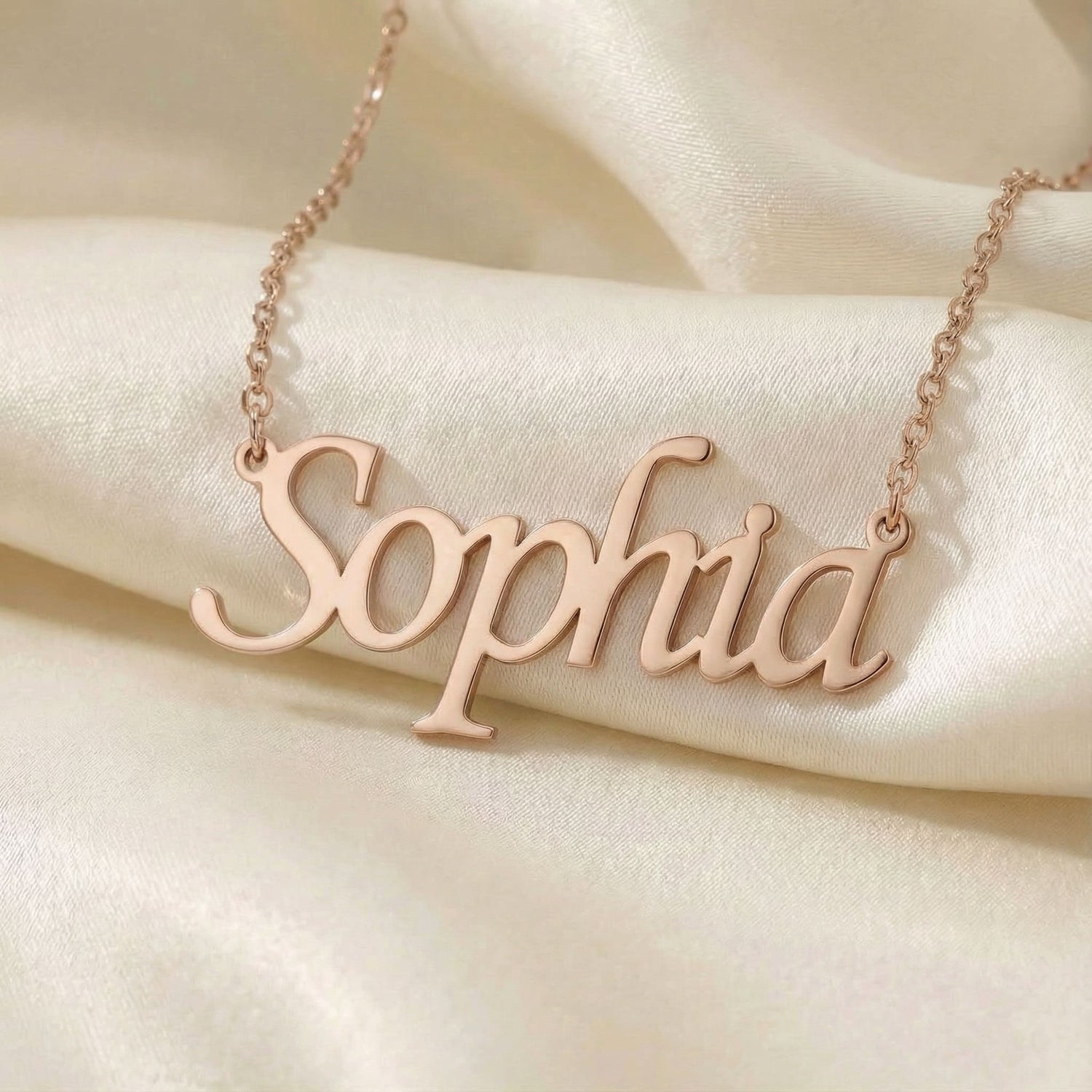 Personalized name necklace in rose gold finish on beige silk fabric