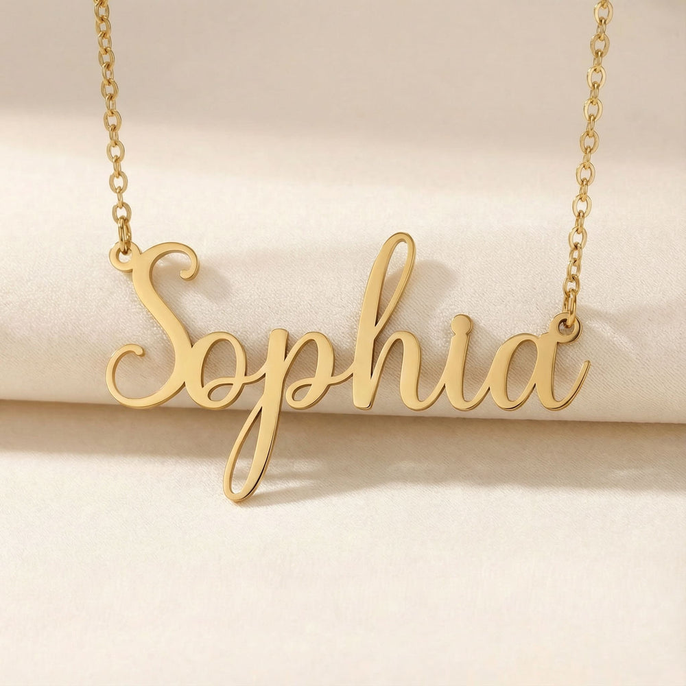 Personalized name necklace in gold finish on beige silk fabric