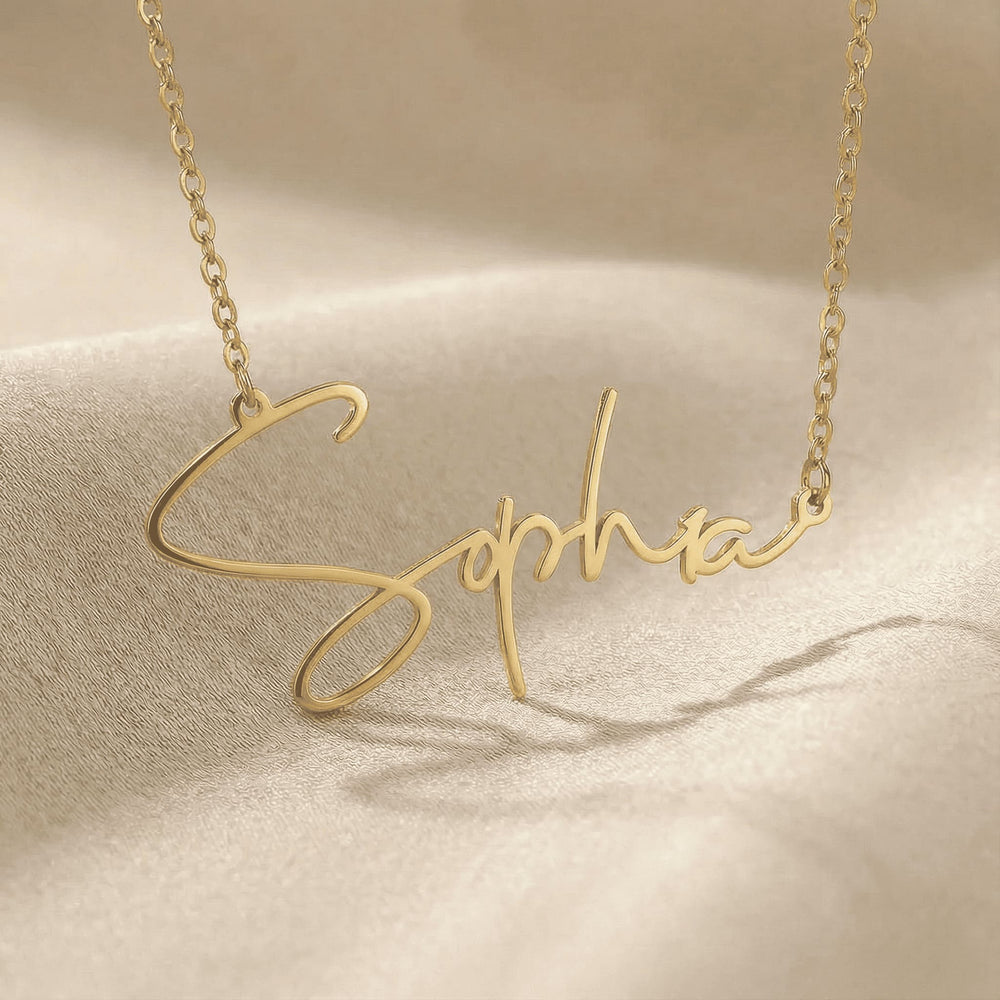Personalized name necklace in gold finish on beige silk fabric