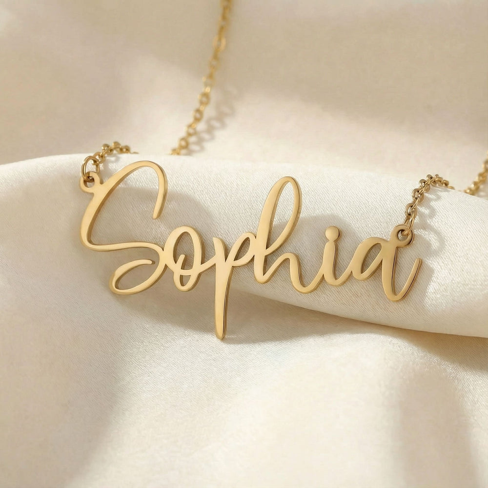 Personalized name necklace in gold finish on beige silk fabric