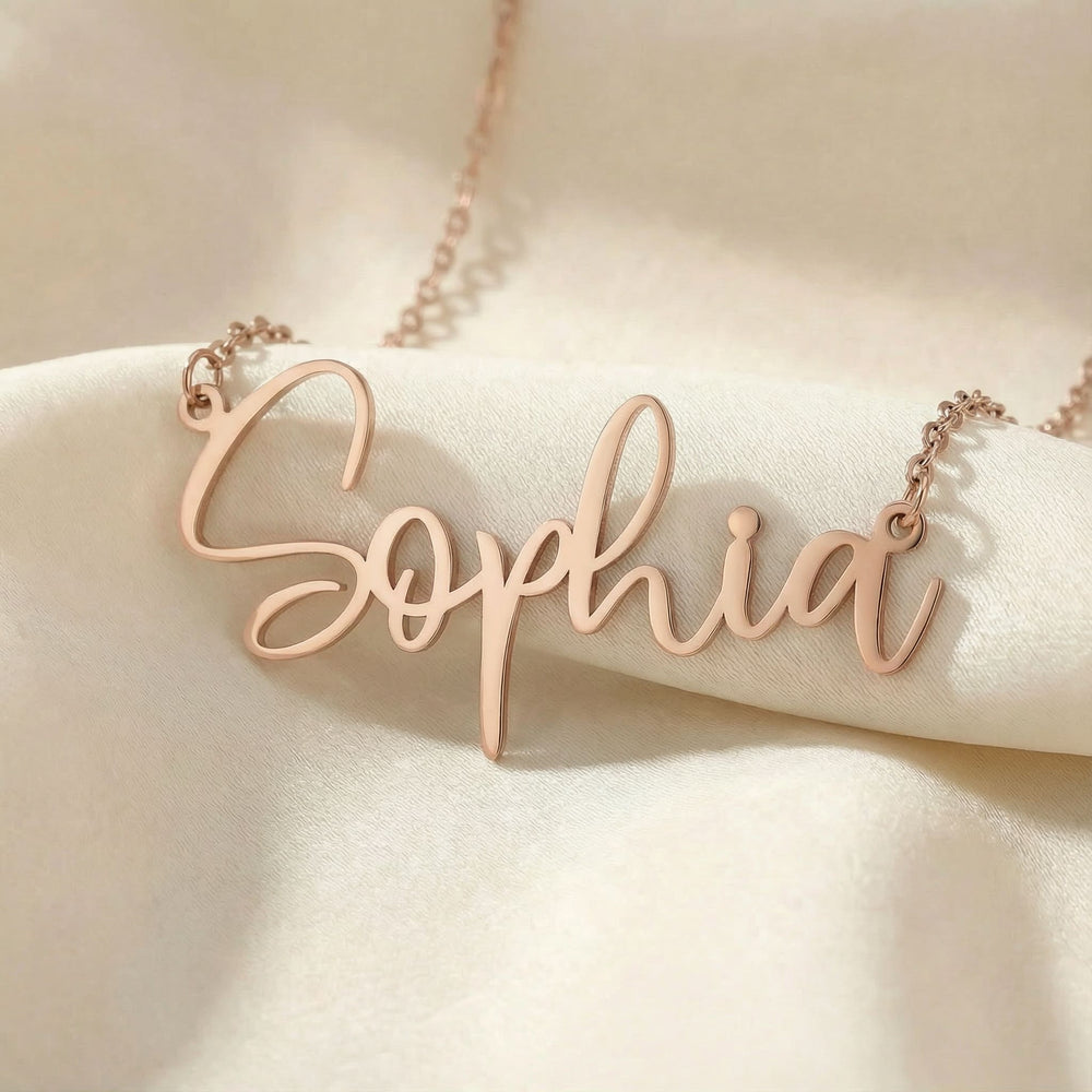 Personalized name necklace in rose gold finish on beige silk fabric