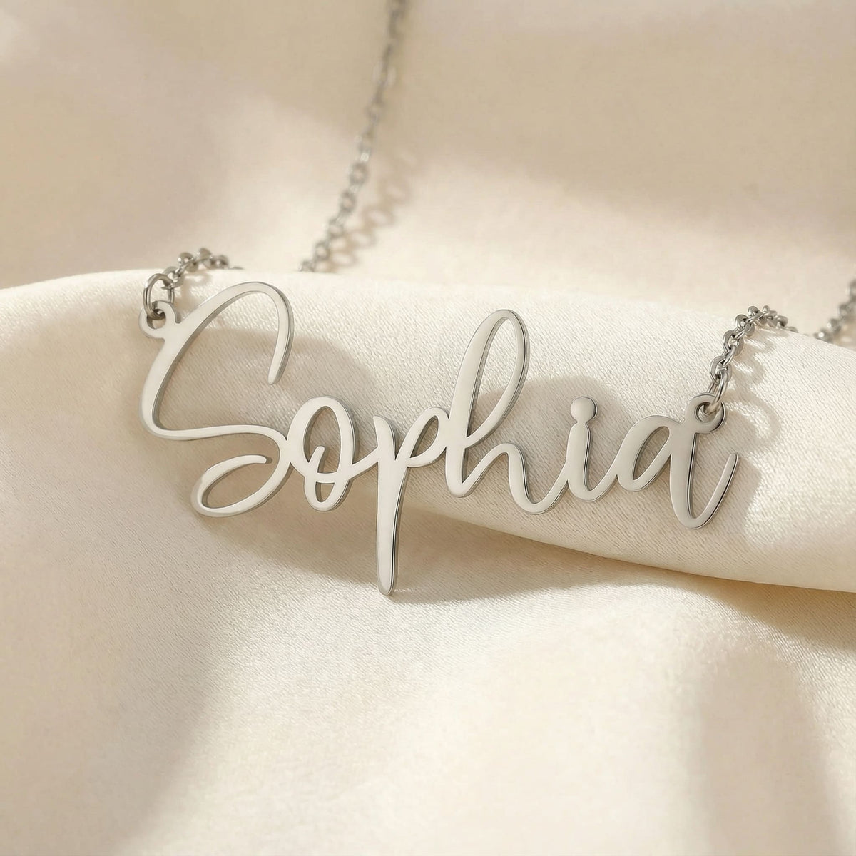 Personalized name necklace in silver finish on beige silk fabric