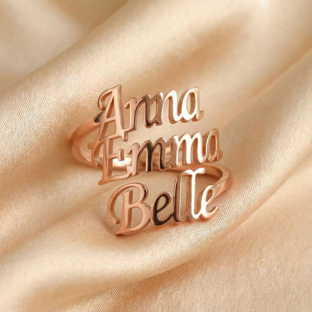 Personalized name ring, one-size in rose gold finish on beige silk fabric