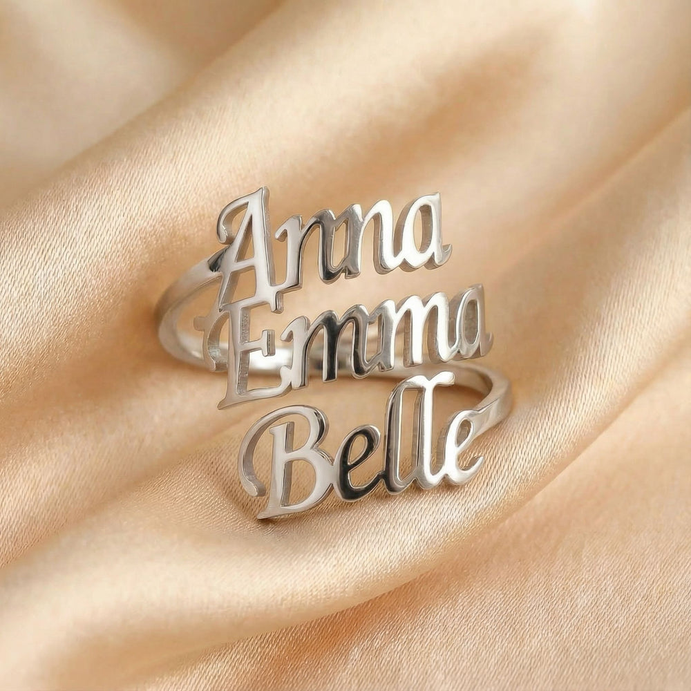 Personalized name ring, one-size in silver finish on beige silk fabric
