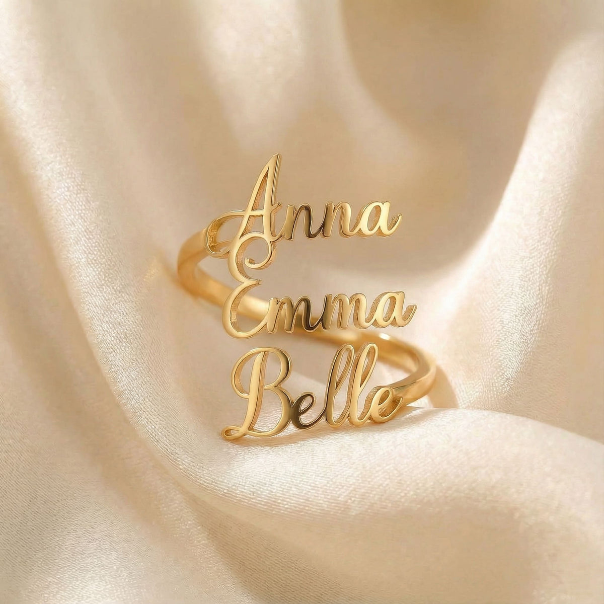 Personalized name ring, one-size in gold finish on beige silk fabric
