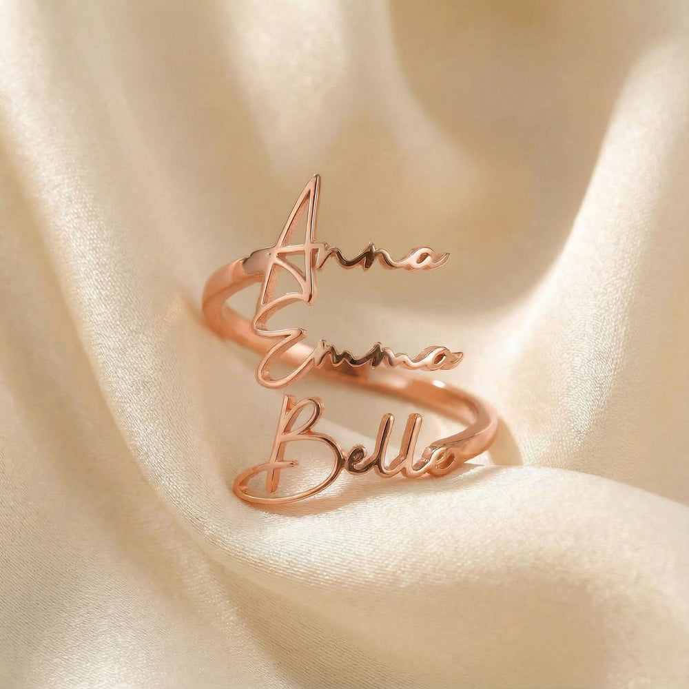 Personalized name ring, one-size in rose gold finish on beige silk fabric