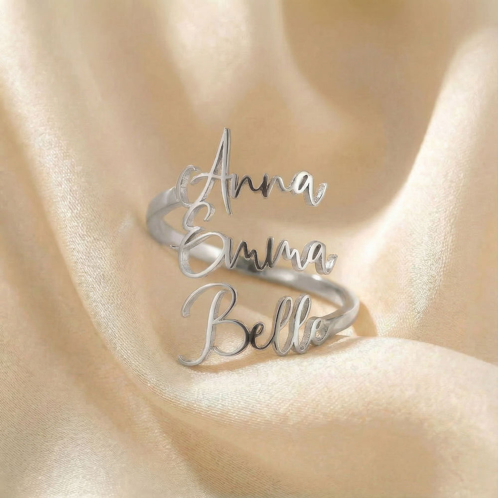 Personalized name ring, one-size in silver finish on beige silk fabric