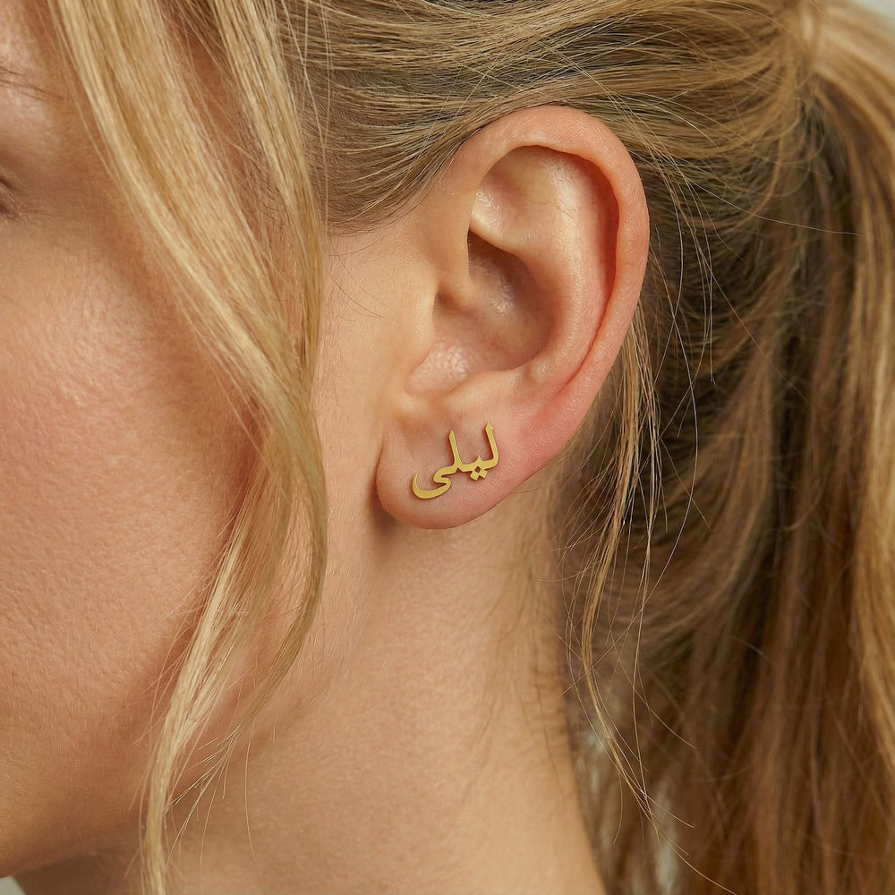 Personalized name ear climber earrings in Arabic in gold finish worn on ear, side profile view
