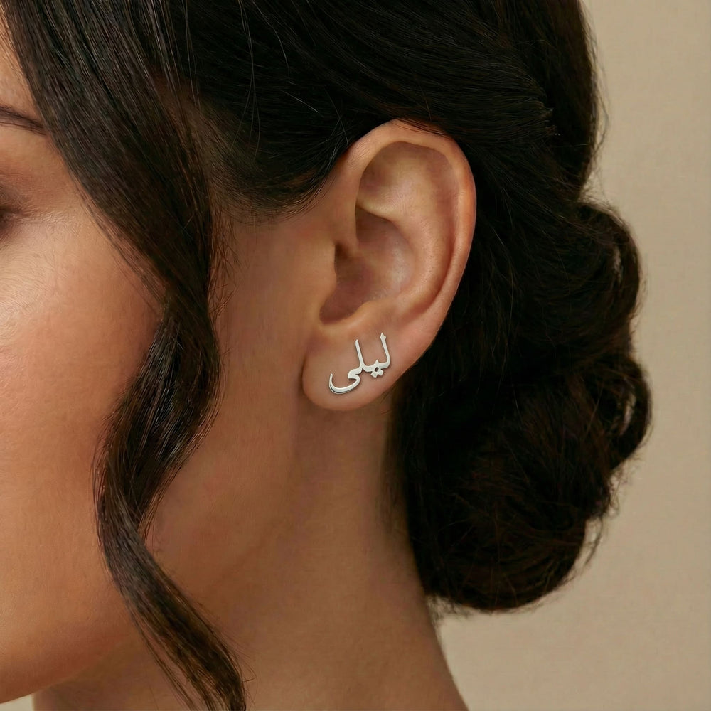 Personalized name ear climber earrings in Arabic in silver finish worn on ear, side profile view