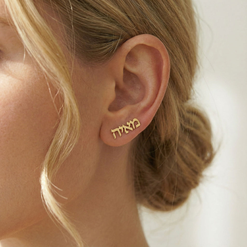 Personalized name ear climber earrings in Hebrew in gold finish worn on ear, side profile view