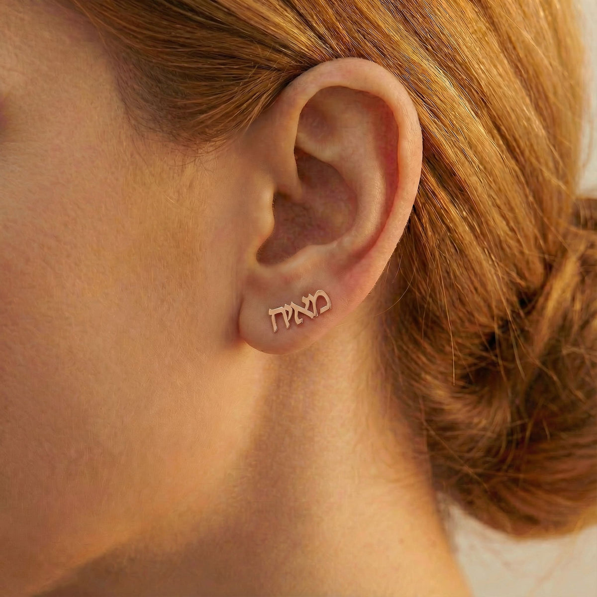 Personalized name ear climber earrings in Hebrew in rose gold finish worn on ear, side profile view