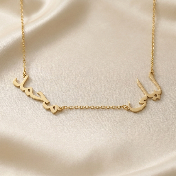 Custom Arabic multiple name necklace in 18K gold plated finish, two separate name pendants in Arabic script spaced along a fine chain on cream silk
