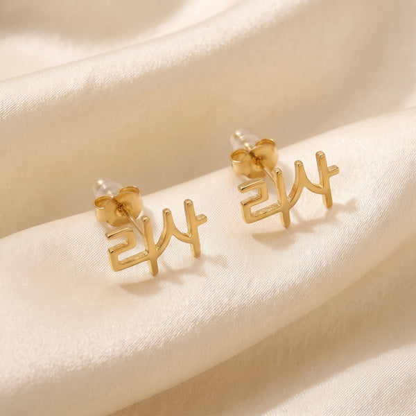 Pair of K-pop idol name ear climber earrings in Korean reading 리사 in 18K gold plating on ivory silk