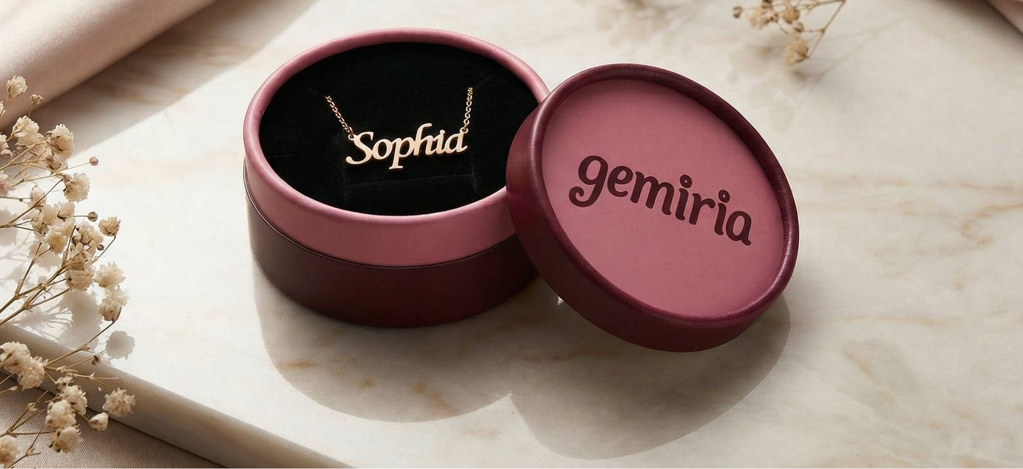 Jewelry box with 'Sofia' necklace and 'gemiria' branding on a marble surface.