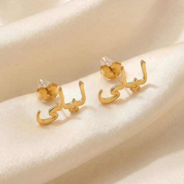 Custom Arabic name ear climber earrings in 18K gold plating reading ليلى, on cream silk