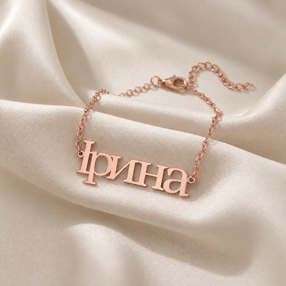Personalized Ukrainian name bracelet reading Ірина in 18K rose gold plating on ivory silk