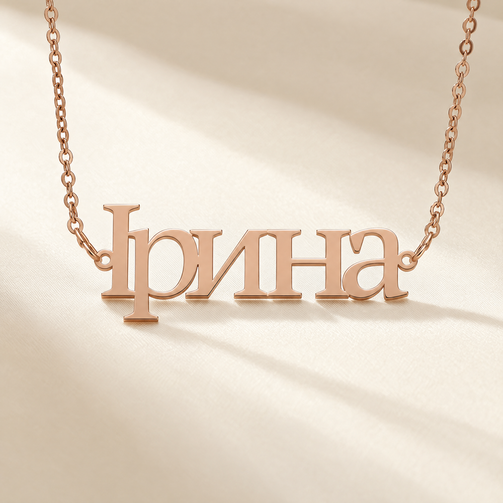 Personalized Ukrainian name necklace reading Ірина in 18K rose gold plating on cream silk