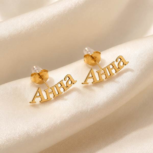Custom Cyrillic name ear climber earrings in 18K gold plating, curved name reading Анна, on ivory silk