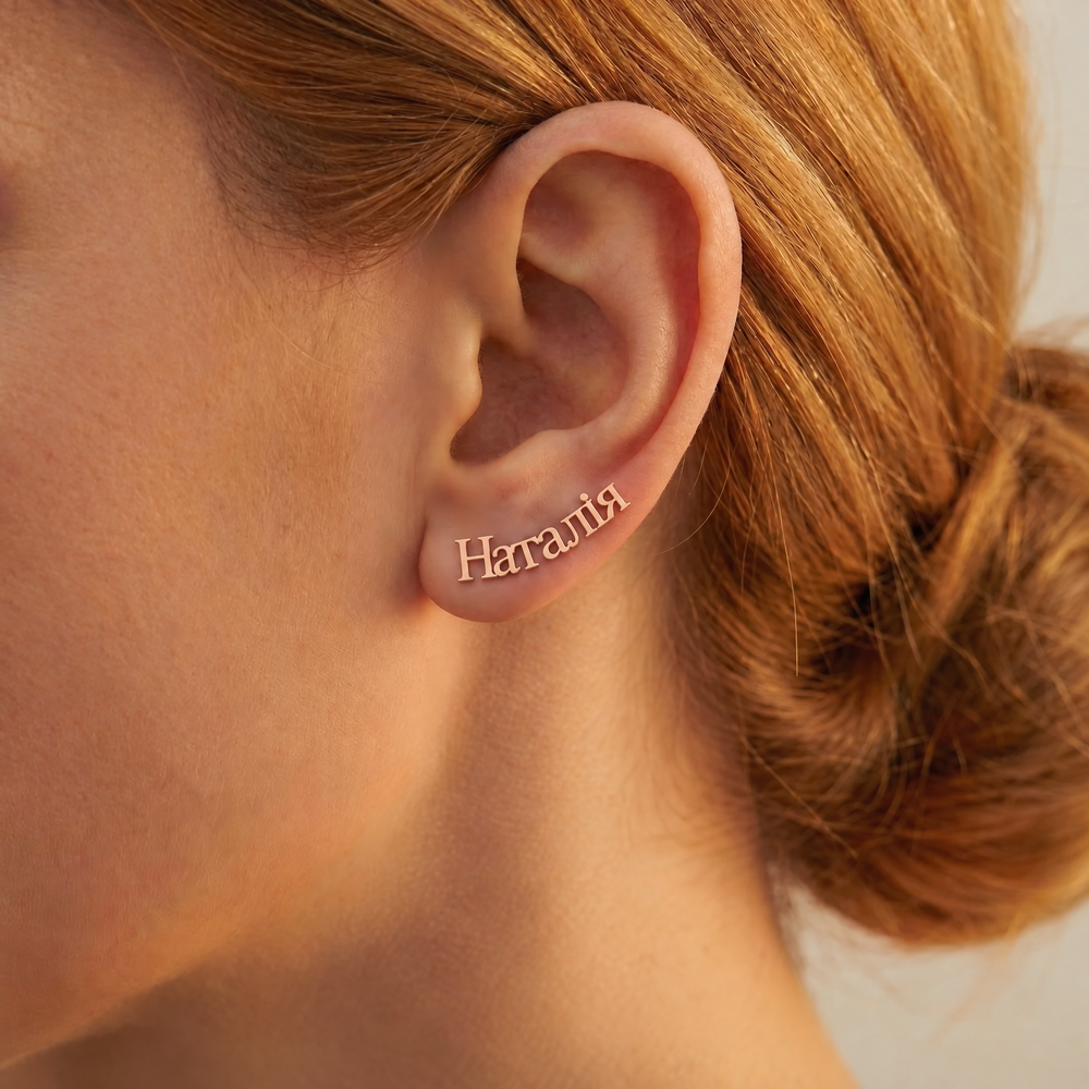 Personalized Ukrainian name ear climber earring reading Наталія in 18K rose gold plating, curving up along the ear