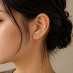 Close-up of gold Japanese Katakana ear climber earrings meaning "Maya"