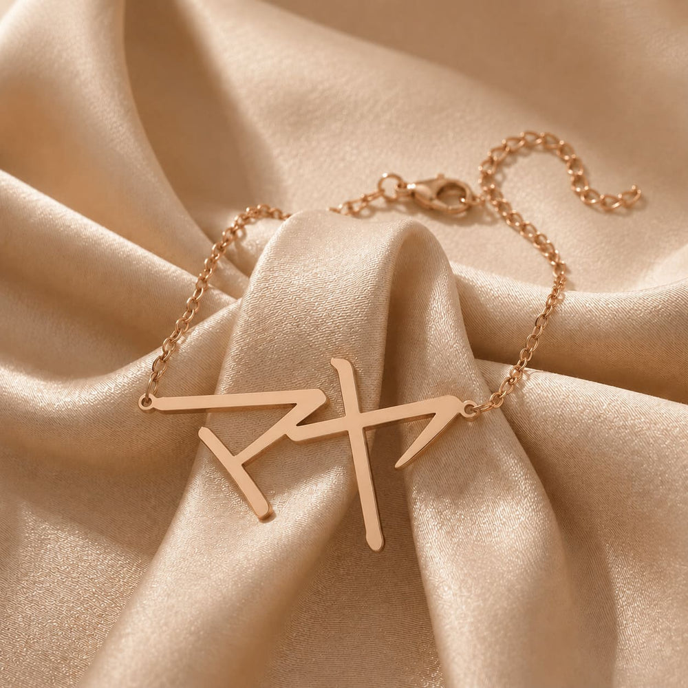Rose gold bracelet with a Japanese Katakana pendant meaning "Maya" on beige fabric