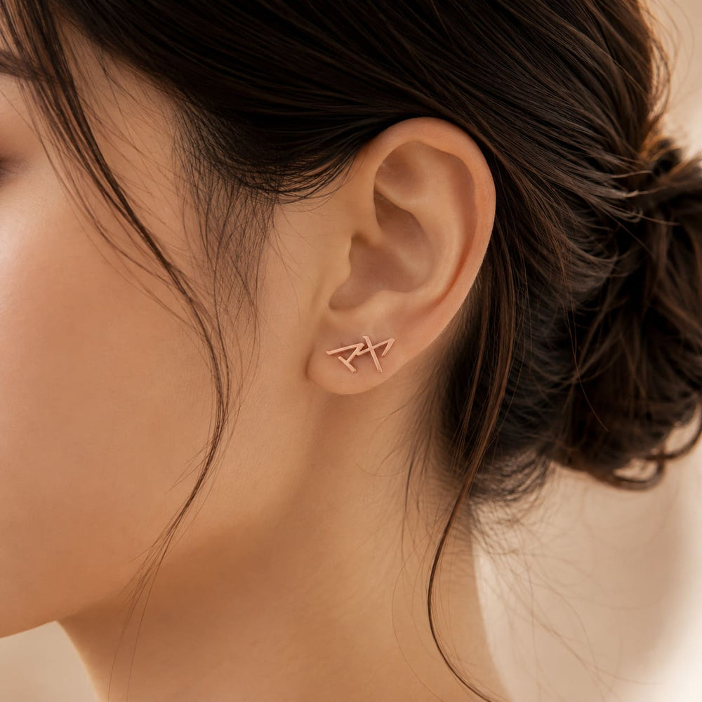 Close-up of rose gold Japanese Katakana ear climber earrings meaning "Maya"
