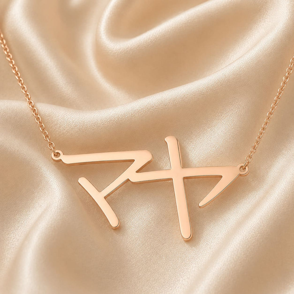 Rose gold necklace with a Japanese Katakana pendant meaning "Maya" on a beige satin background