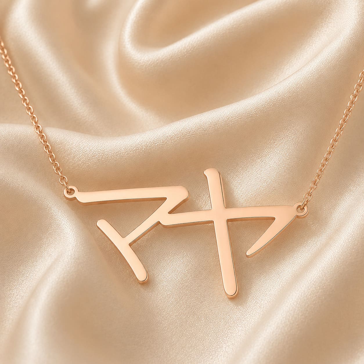 Rose gold necklace with a Japanese Katakana pendant meaning "Maya" on a beige satin background