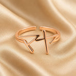Rose gold ring with Japanese Katakana pendant meaning "Maya" on a beige fabric background