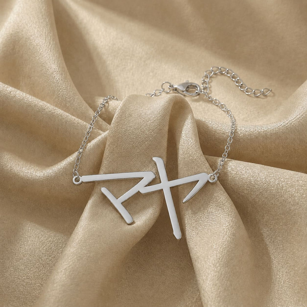 Silver bracelet with a Japanese Katakana pendant meaning "Maya" on beige fabric