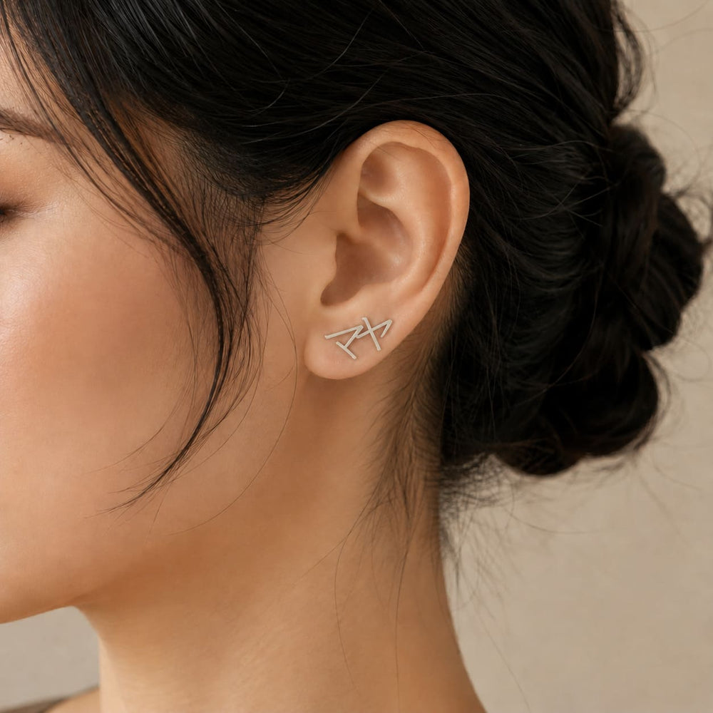 Close-up of silver Japanese Katakana ear climber earrings meaning "Maya"