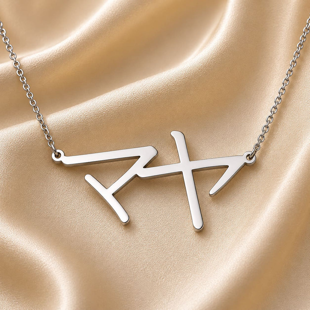 Silver necklace with a Japanese Katakana pendant meaning "Maya" on a beige fabric background